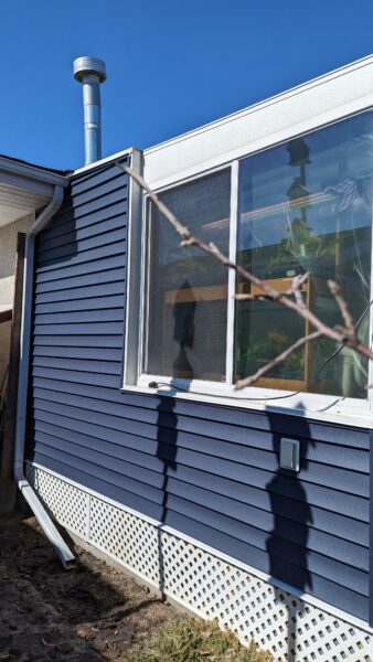 Remove vinyl siding and install new royal Navy Blue siding on sunroom of home