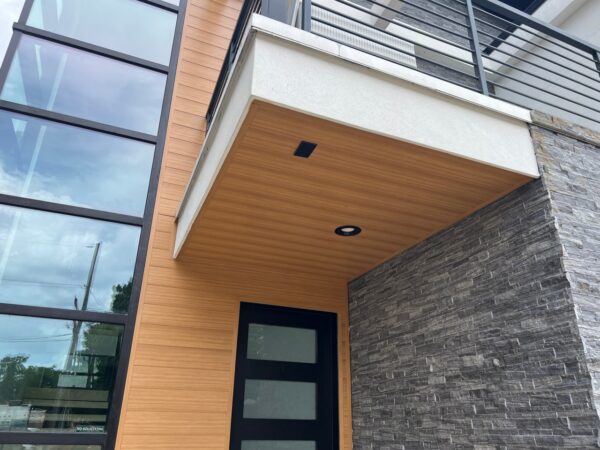 Replaced wood siding with Sagiper SagiWall v groove siding in Caramel Zebra color and front entrance ceiling with SagiRev soffit in same color.